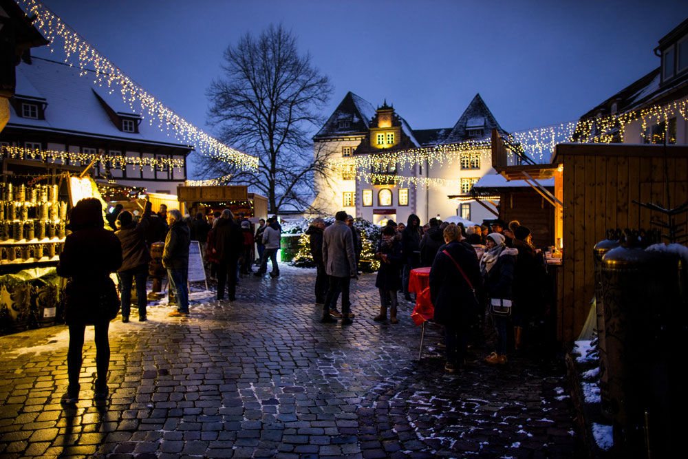 Blick auf den erleuchteten Schlosshof mit Weihnachtsmarktbuden